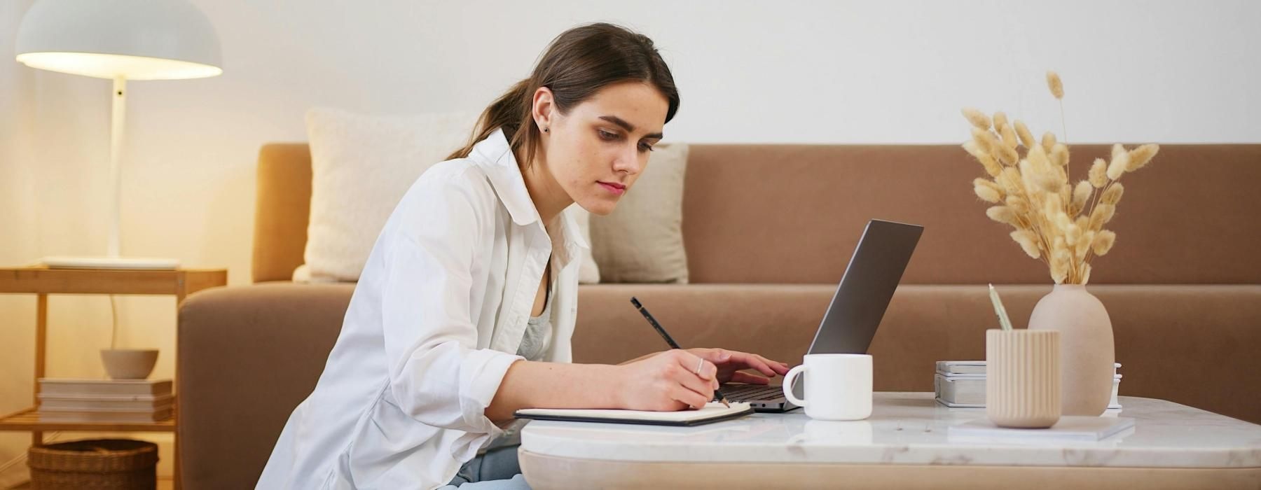a woman sitting on a couch using a laptop